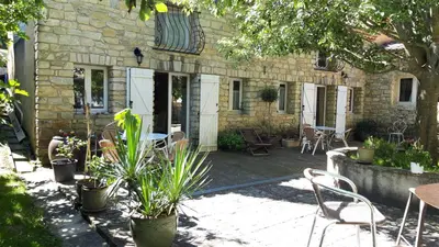 a patio with chairs and plants in front of a building at Mini gite foulon in Crillon-le-Brave