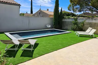 a backyard with a swimming pool and chairs and grass at Villa Lisa - piscine chauffée in LʼIsle-sur-la-Sorgue
