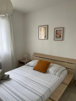 a bed with a wooden frame in a bedroom at Villa Lisa - piscine chauffée in LʼIsle-sur-la-Sorgue