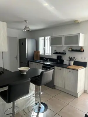 a kitchen with a black counter top with a stove at Villa Anna - piscine privée proche du centre historique in LʼIsle-sur-la-Sorgue