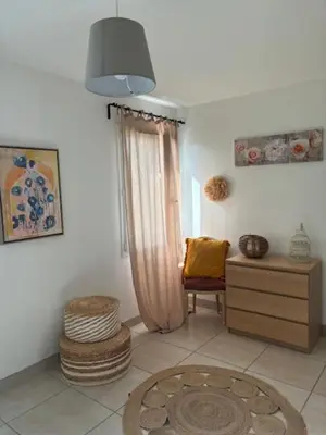 a living room with a chair and a dresser at Villa Anna - piscine privée proche du centre historique in LʼIsle-sur-la-Sorgue