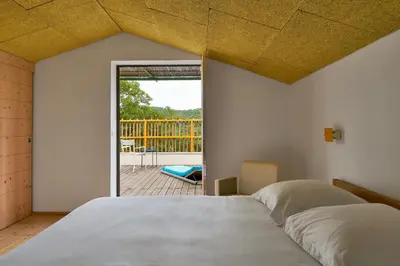 a bedroom with a bed and a view of a deck at Domaine La Ferme HI bride in Villelaure
