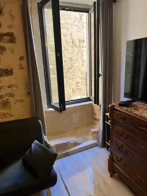 a living room with a large flat screen tv and a window at APPARTEMENT CAROMB proche Mont VENTOUX avec clim in Caromb