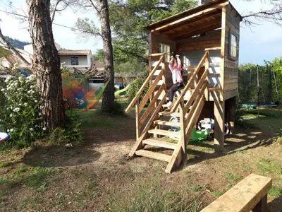 a woman standing on the stairs of a play house at Chambres tomate, dans maison avec petit escalier à 6km du festival de piano de la roque d'anthéron in Rognes