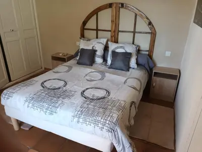 a bedroom with a large bed with a wooden headboard at Chambres tomate, dans maison avec petit escalier à 6km du festival de piano de la roque d'anthéron in Rognes