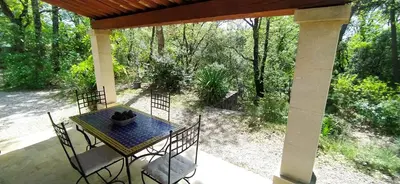 a patio with a table and chairs on a porch at Villa Chênaie in Bédoin