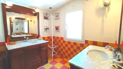 a bathroom with two sinks and a mirror and a window at Villa Chênaie in Bédoin