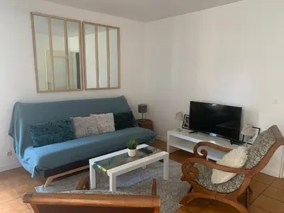 a living room with a blue couch and a tv at Beau T2 clim terrasse idéalement situé in Aix-en-Provence
