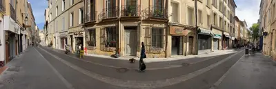 an empty city street with buildings and an umbrella at Lou Pitchoun in Aix-en-Provence