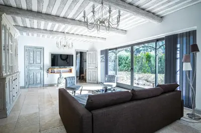 a living room with a couch and a table at Gîte tout confort - jardin et piscine in Lagnes