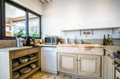 a kitchen with a sink and a microwave at Gîte tout confort - jardin et piscine in Lagnes