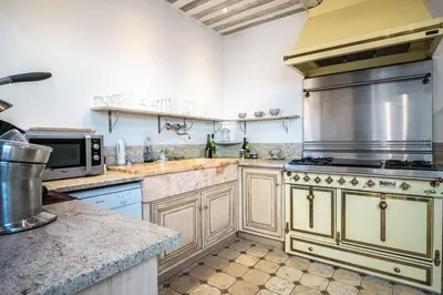 a kitchen with a stove and a microwave at Gîte tout confort - jardin et piscine in Lagnes