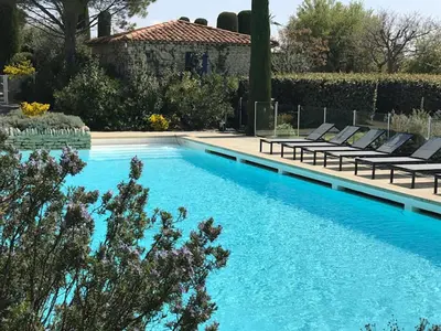 a swimming pool with lounge chairs next to a house at Bastidon avec piscine Gordes Lubéron in Gordes
