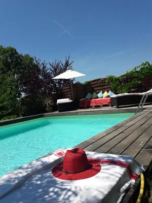 a red hat sitting on the edge of a swimming pool at Le jardin de Sabine in Éguilles