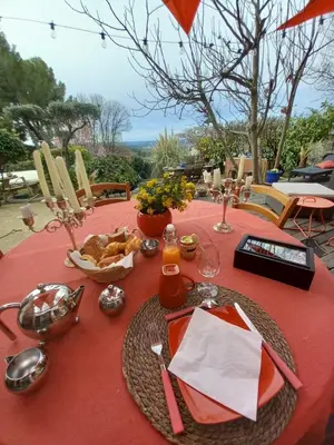a table with a red table cloth with food on it at Le jardin de Sabine in Éguilles