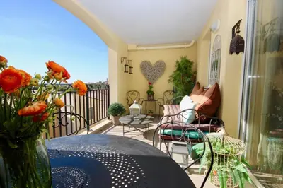 a balcony with a vase of flowers on a table at Apartement Beata in Provence, Golf Pont Royal in Mallemort