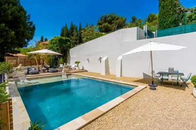 a swimming pool with an umbrella and a table at La Chambre Cézanne in Aix-en-Provence