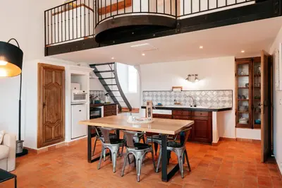 a kitchen with a wooden table and chairs at Domaine Perréal Les Gîtes in Gargas