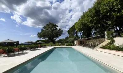 a swimming pool with chairs and umbrellas at Domaine Perréal Chambres d'hôtes in Gargas