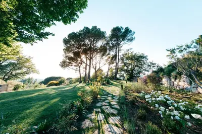 a garden with flowers and trees on a field at Domaine Perréal Chambres d'hôtes in Gargas