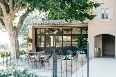 a patio with a table and chairs in front of a building at Domaine Perréal Chambres d'hôtes in Gargas