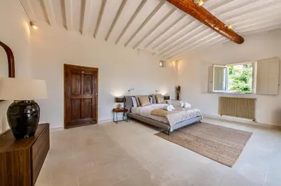 a bedroom with a bed and a wooden ceiling at Le Mas Victoria in Gordes
