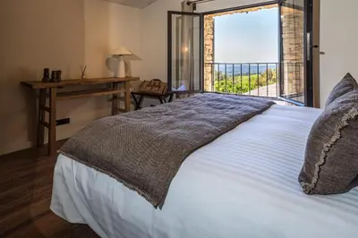 a bedroom with a bed with a window and a desk at Le Mas Luca in Gordes