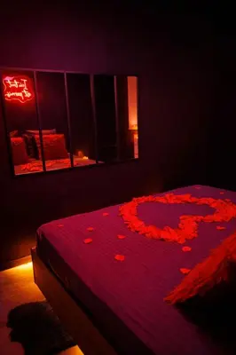 a bedroom with a bed with red flowers on it at Eden House, Cocon sensuel et romantique avec jacuzzi in Carpentras