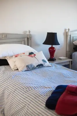 a bed with a blanket and a lamp on a table at La Bastide Neuve in Joucas