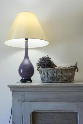 a lamp sitting on top of a table with a basket at La Bastide Neuve in Joucas