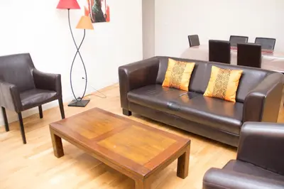 a living room with a leather couch and a coffee table at Appartement de Charme in Aix-en-Provence