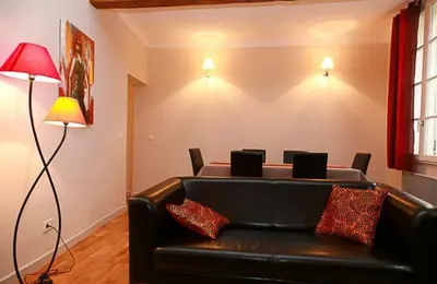 a living room with a leather couch and a table at Appartement de Charme in Aix-en-Provence