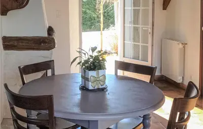a dining room table with a vase of flowers on it at Gorgeous Home In Roussillon With Wifi in Roussillon