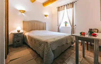 a bedroom with a bed and a table and a window at Gorgeous Home In Roussillon With Wifi in Roussillon