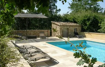 a swimming pool with lounge chairs next to a house at Gorgeous Home In Roussillon With Wifi in Roussillon