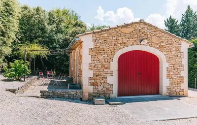 a brick building with a red door in a yard at Gorgeous Home In Lioux With Wifi in Lioux