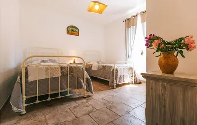 a bedroom with two beds and a vase of flowers at Gorgeous Home In Lioux With Wifi in Lioux
