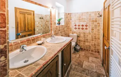 a bathroom with two sinks and a toilet at Gorgeous Home In Lioux With Wifi in Lioux