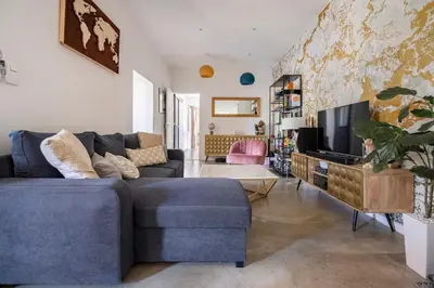 a living room with a blue couch and a tv at Maison de Charme en Provence avec jardin et piscine in Carpentras
