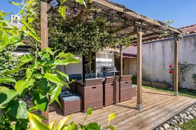 a wooden deck with chairs and a pergola at Maison de Charme en Provence avec jardin et piscine in Carpentras