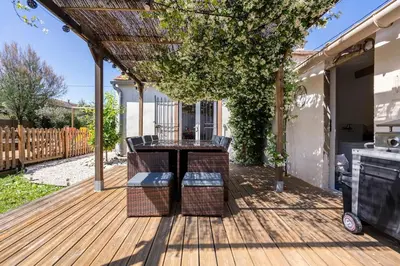 a patio with a table and chairs on a wooden deck at Maison de Charme en Provence avec jardin et piscine in Carpentras