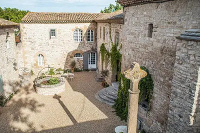 an old stone building with a cross in front of it at Prieuré Notre-Dame de Conil - 12e siècle in Rognes