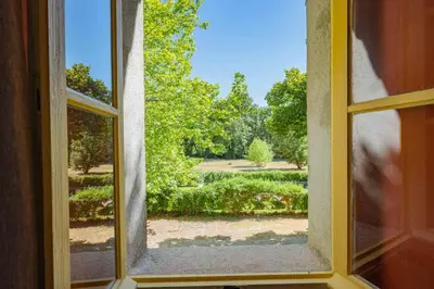 an open window with a view of a garden at Prieuré Notre-Dame de Conil - 12e siècle in Rognes