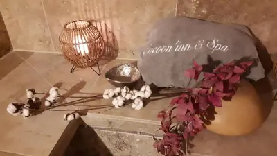 a table with a lamp and a vase with flowers at Cocoon inn&Spa in Saint-Saturnin-les-Avignon