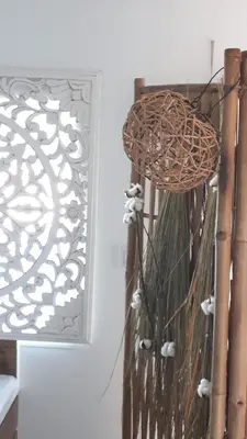 a wicker basket hanging on a wall next to a mirror at Cocoon inn&Spa in Saint-Saturnin-les-Avignon