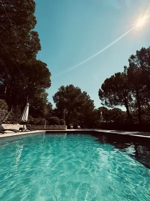 a swimming pool with blue water in a yard at Provence mon amour in La Tour-dʼAigues
