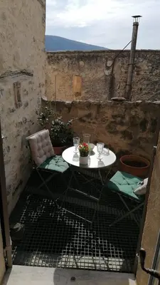 a small white table and chairs on a patio at La Maison d’Helene & Antoine à Bonnieux XII siècle in Bonnieux