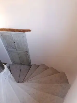 a staircase in a room with a wooden door at La Maison d’Helene & Antoine à Bonnieux XII siècle in Bonnieux