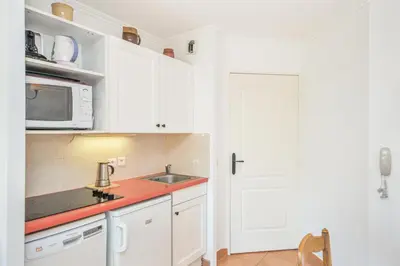 a kitchen with white cabinets and a sink and a microwave at Village Pont Royal en Provence - maeva Home - Studio climatisé 4 Personnes - Sélection MAE-7498 in Mallemort