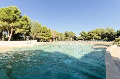 a swimming pool with people in the water at Village Pont Royal en Provence - maeva Home - Appartement moderne climatisé 4 pièces 8 personnes - Sélection - super Home MAE-8568 in Mallemort